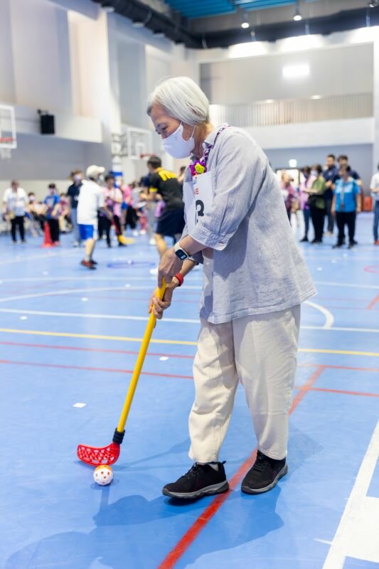 台灣生活復能健康促進協會等團體，4月共同舉辦全齡共融運動會，圖為長輩參與團體賽項目「推推曲棍球」。（圖片來源/好童年）