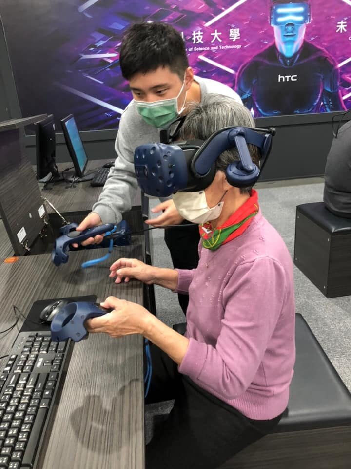 資訊管理系的學生帶領長輩體驗VR虛擬實境科技，刺激長者感官刺激。(圖片來源/謙和賀日照中心)
