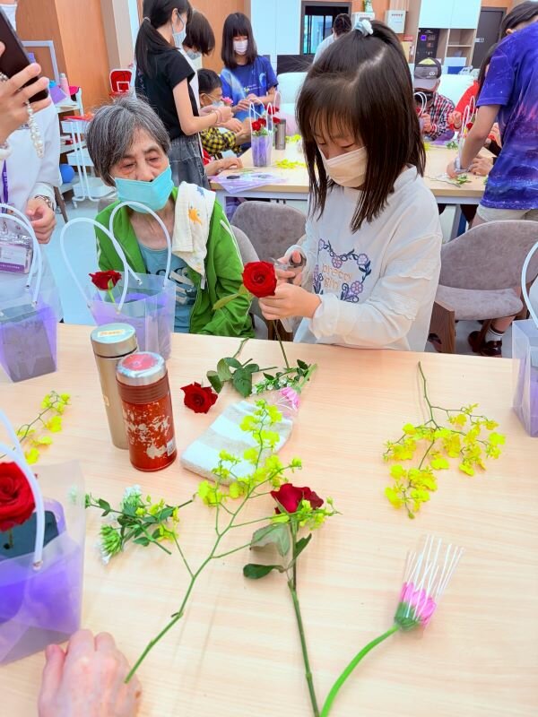 青銀共學，木柵國小學童走進日照與阿公阿嬤一起學習插花。(圖片來源/圓石社區長照機構)