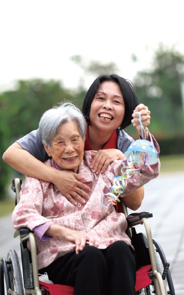 邱秋華與長輩在庭院散步。