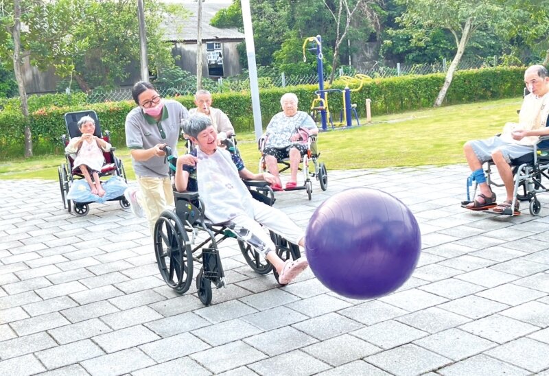 吾老莊的庭院裡，照服員與長輩正在遊戲。