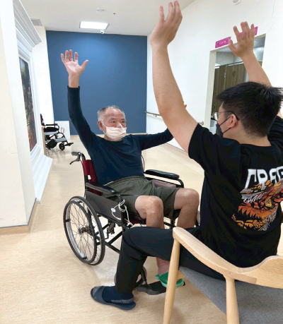 長輩在治療師的帶領下進行復健活動。