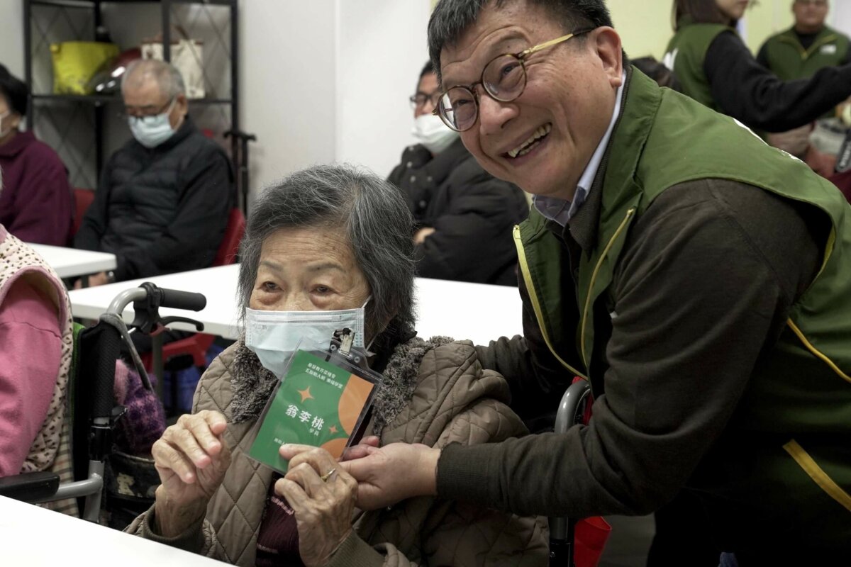 芥菜種會執行長李肇家(右一)為五股助人網「樂福學堂」長者們掛學生證，給予愛的祝福。（芥菜種會提供）