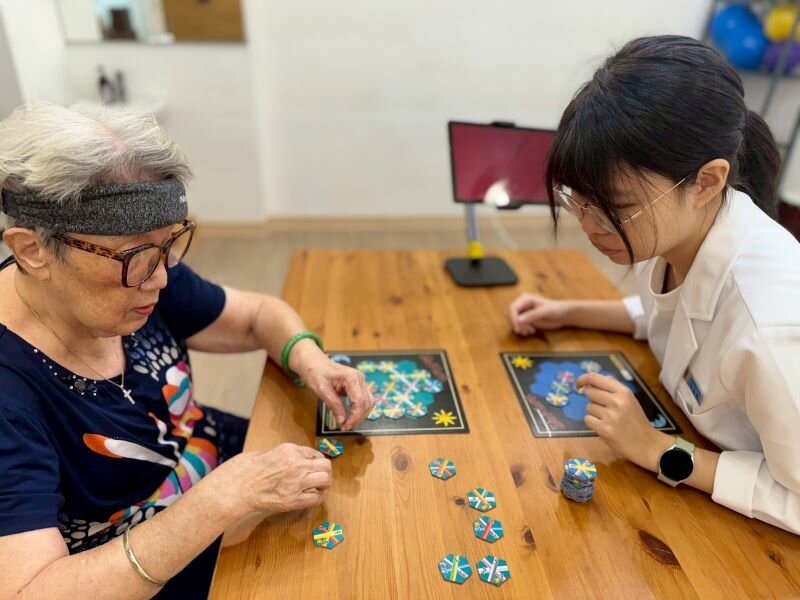長輩與治療師進行「腦健升計 劃」。(圖片來源/起辰聯合治療所)