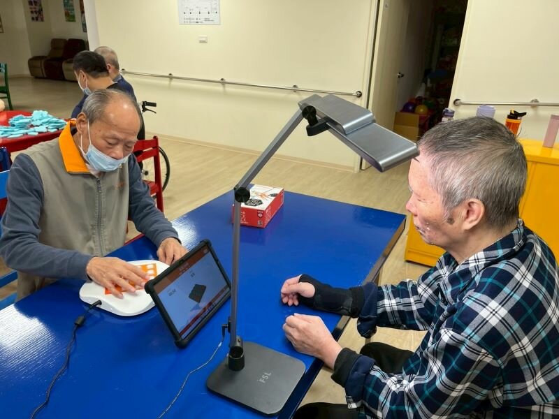長者正在使用認知訓練機與護智燈。（圖片來源/樂智日照中心）