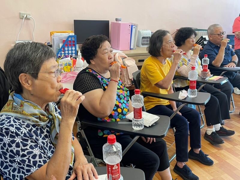 長輩參加「吞嚥健聲房」，用卡祖笛哼唱訓練口腔。（圖片來源/李壬㛙）