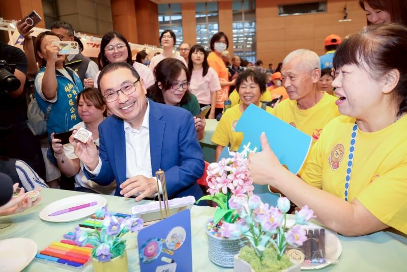  新北積極媒合民間機構提供失智長輩社會處方箋場域，市長侯友宜 （左前）親自體驗為長輩設計的手作活動。(圖片來源/新北市政府)
