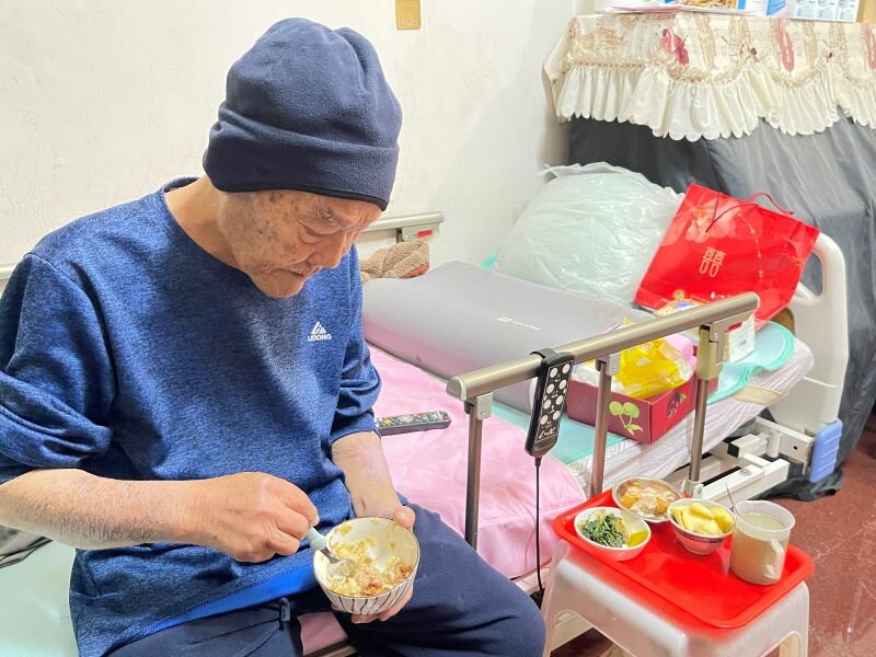 歷經三個月的進食與咀嚼吞嚥照護，陳阿公移除鼻胃管，一口一口慢慢吃飯。（攝影/戴淨妍）