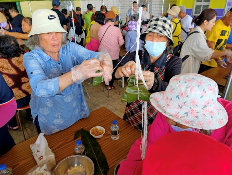 綠色照顧計畫中的「綠飲食」強調地產地銷、營養健康、文化傳承，圖為三民社區、博愛社區結合成功鎮農會家政班，選用台東成功盛產的鬼頭刀與木虌果包粽。（圖片來源／農村水保署）